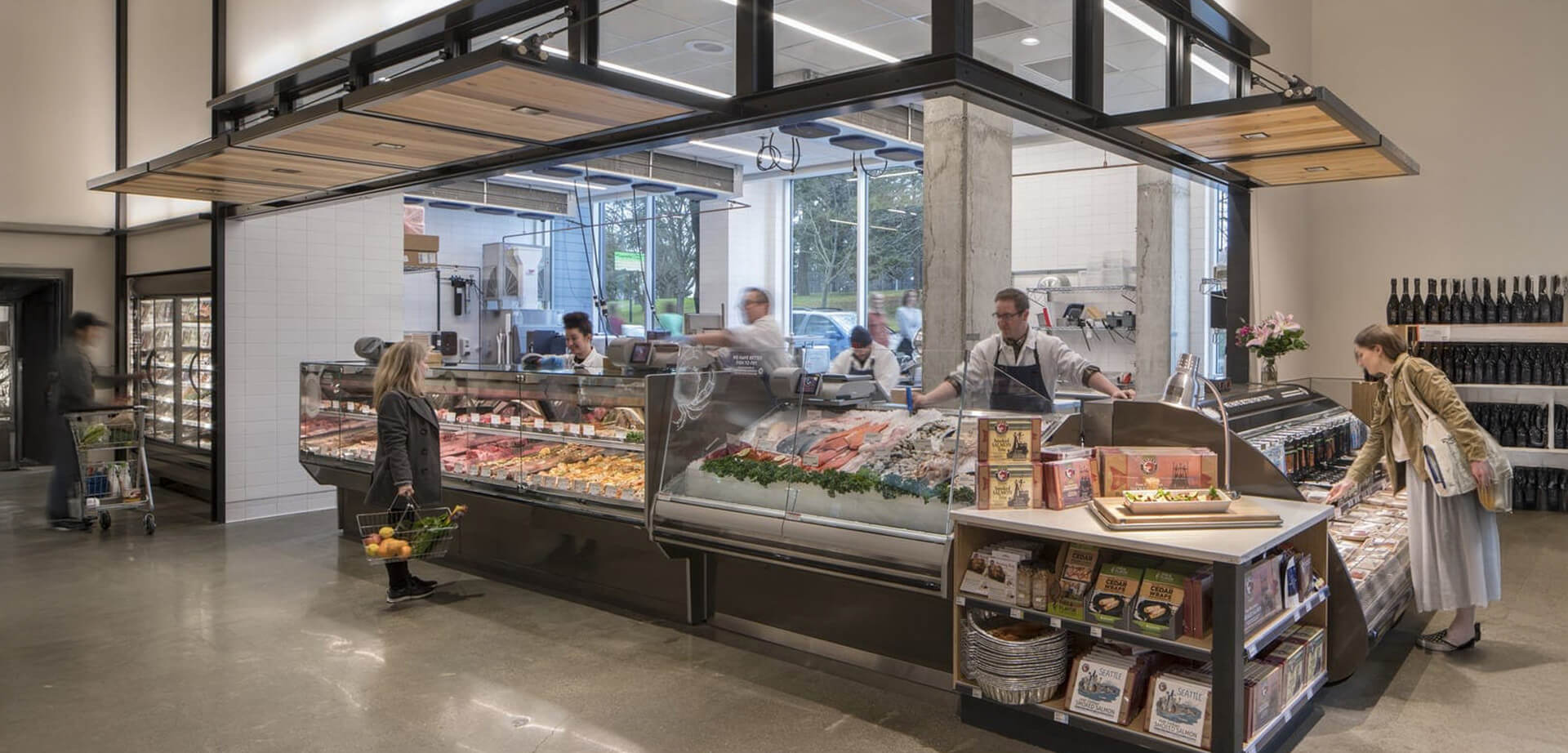 PCC Community Markets is a consumer-owned food cooperative based in Seattle, Washington.  The store features a prominent, well-lit meat and seafood counter with staff assisting customers. 