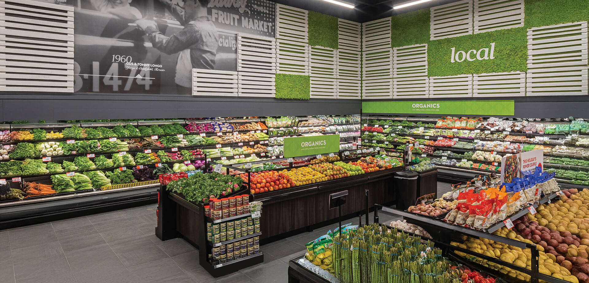 Longo's is a family-operated Canadian grocery chain that began as a fruit market in 1956.  The store design features prominent signage for "Organics" and "local" produce.  The black and white mural in the background references the company's founding year of 1960. 