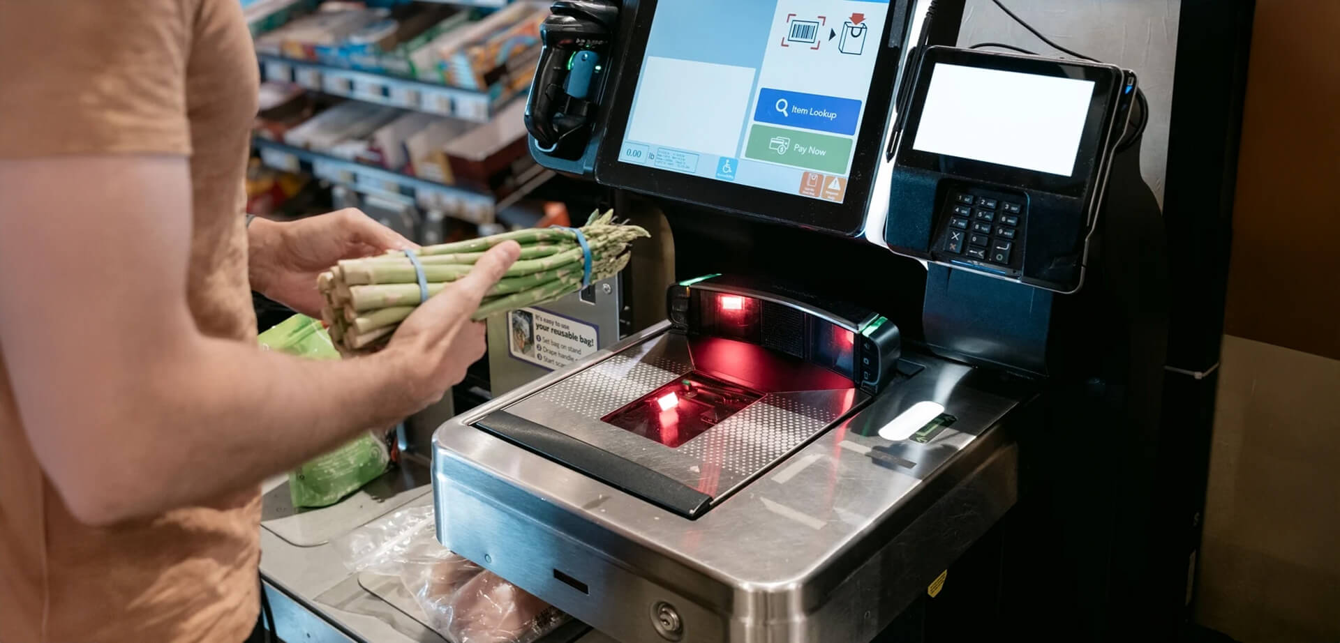The image shows a person using a self-checkout machine in a supermarket. This technology allows customers to scan, bag, and pay for their purchases independently without the need for a cashier. 