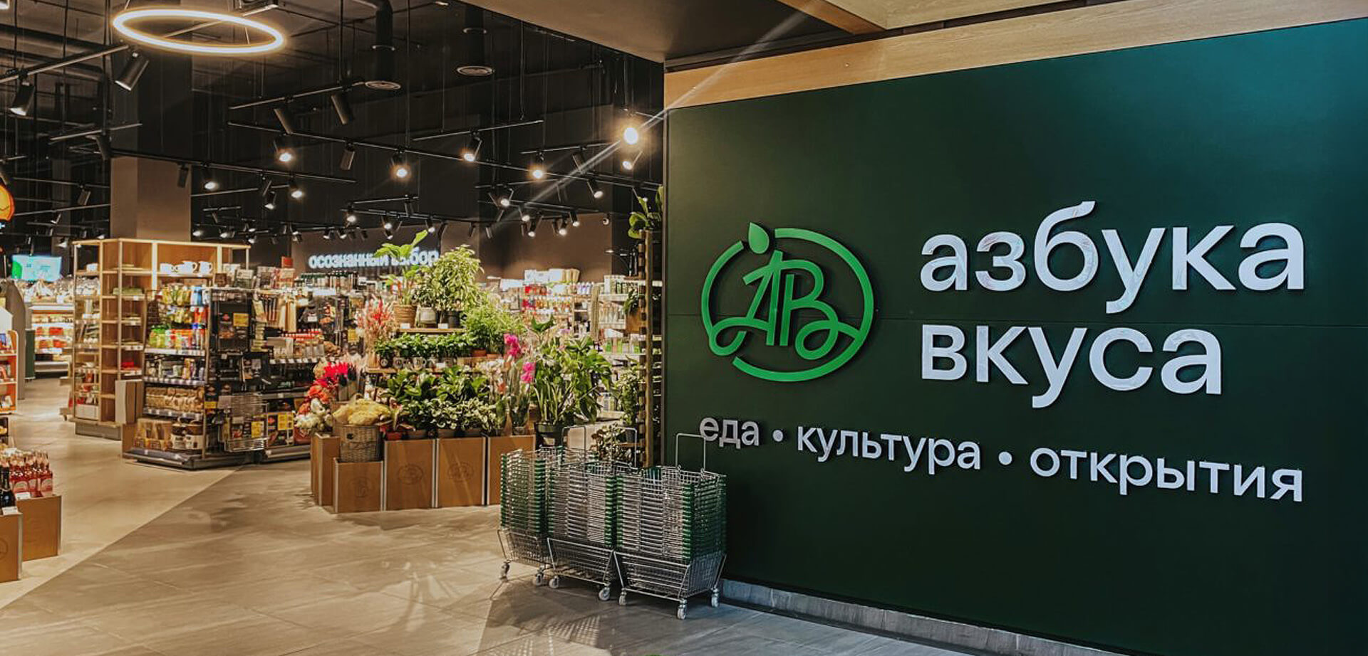 The image shows the interior and signage for a Russian premium supermarket chain called Azbuka Vkusa. 