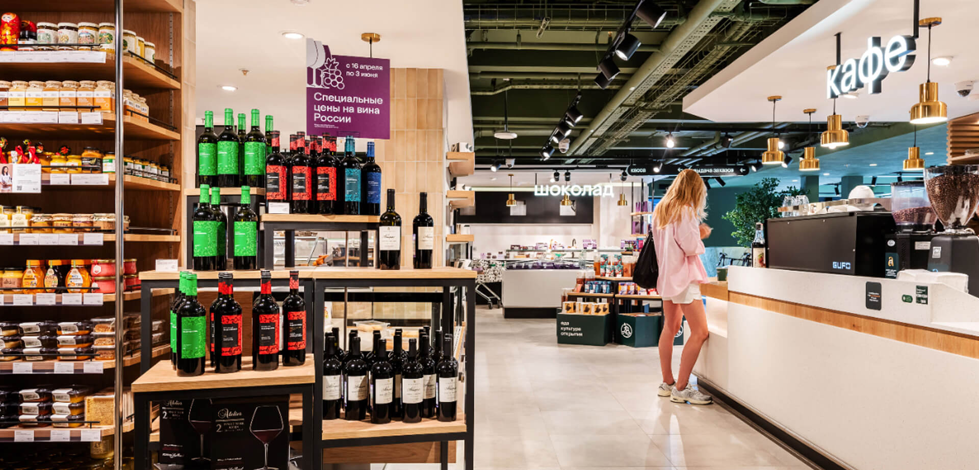 Azbuka Vkusa supermarket the cafe area is identifiable by the large "кафе" sign above the counter. There are also "шоколад" signs, indicating a chocolate or dessert section.  department interior design.