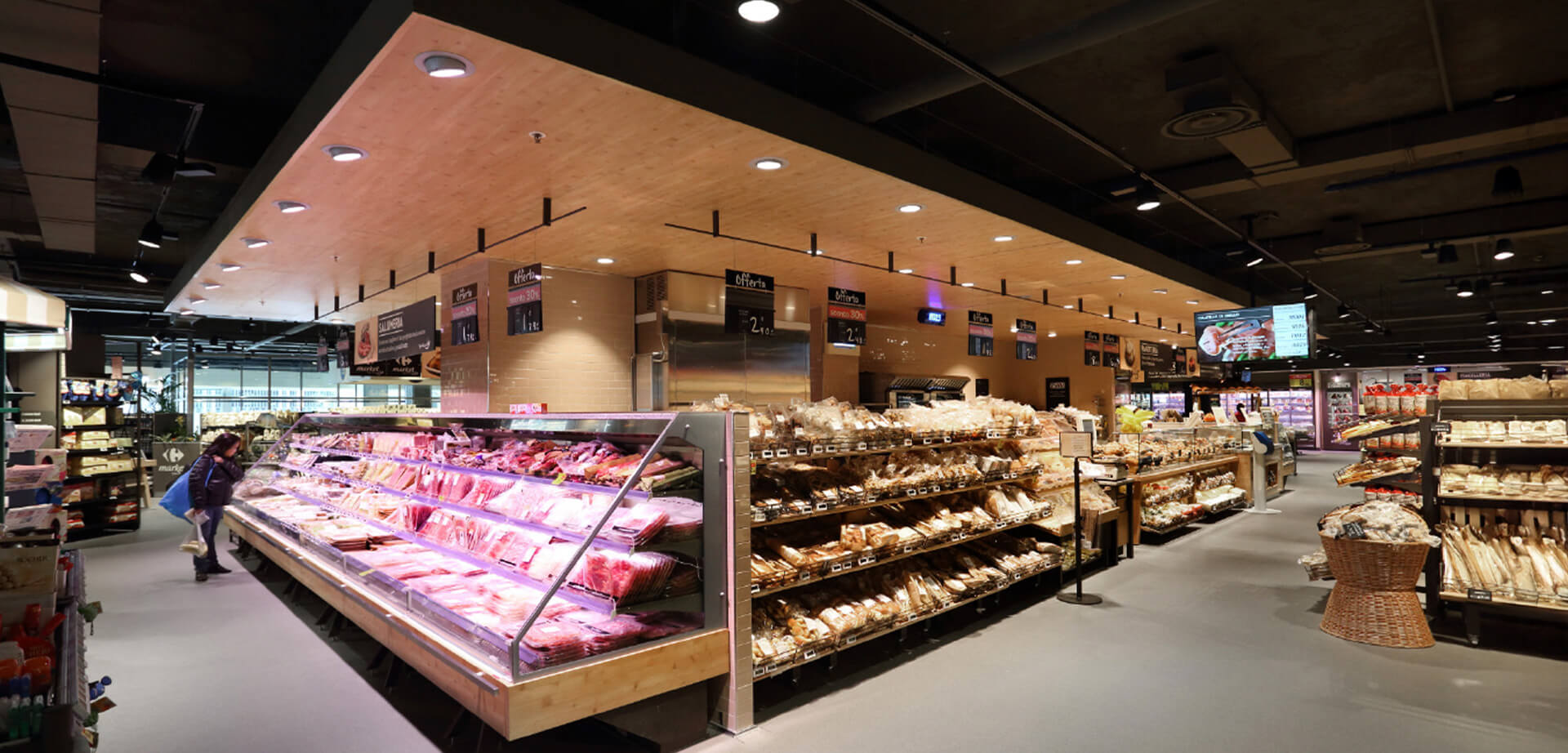 A Carrefour Gourmet market store. The store concept focuses on fresh products and a modern market style. It features extensive fresh food counters, including a large butchery section with various meat cuts displayed. 