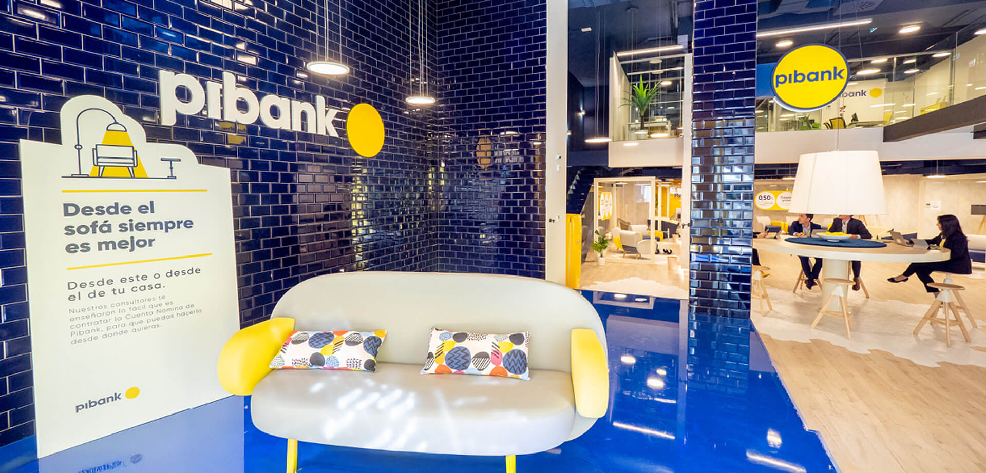 The image displays the interior of a Pibank branch office, a financial institution that is a brand of Pichincha Bank