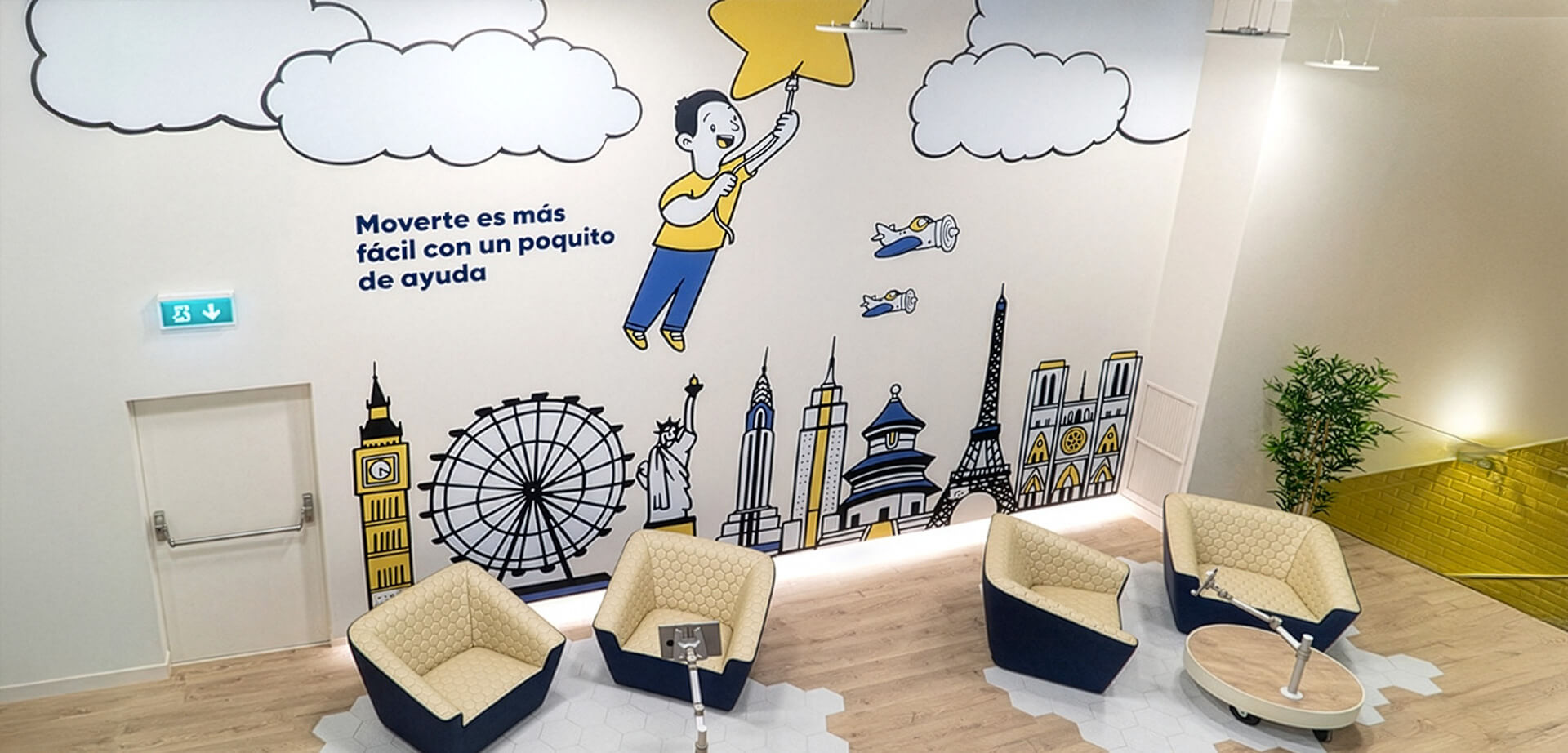 The image is of a Pibank office.  Theme: The mural depicts an international theme with landmarks like Big Ben, the Statue of Liberty, and the Eiffel Tower.  Message: The text emphasizes the ease of progress with help.
