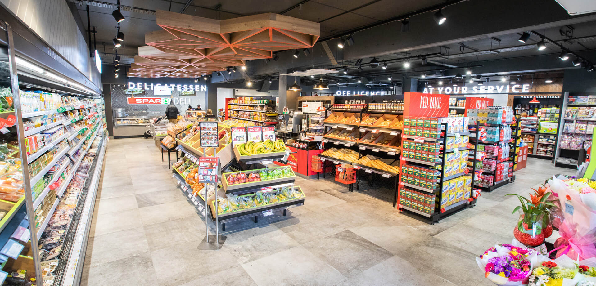 Spar Deli Convenience Store. Die Ladengestaltung legt Wert auf frische Produkte, eine Feinkosttheke und „Essen zum Mitnehmen“-Optionen.