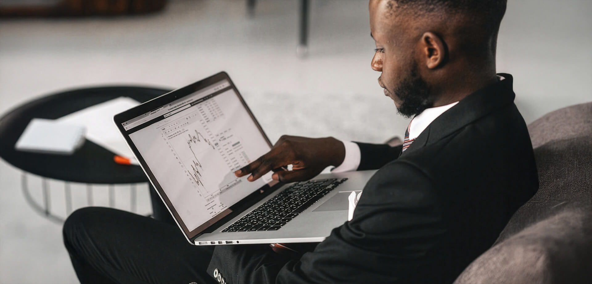 A businessman analyzing financial charts on a Lloyds laptop screen.  Financial analysis involves reviewing balance sheets and cash flow statements to assess a company's health. 