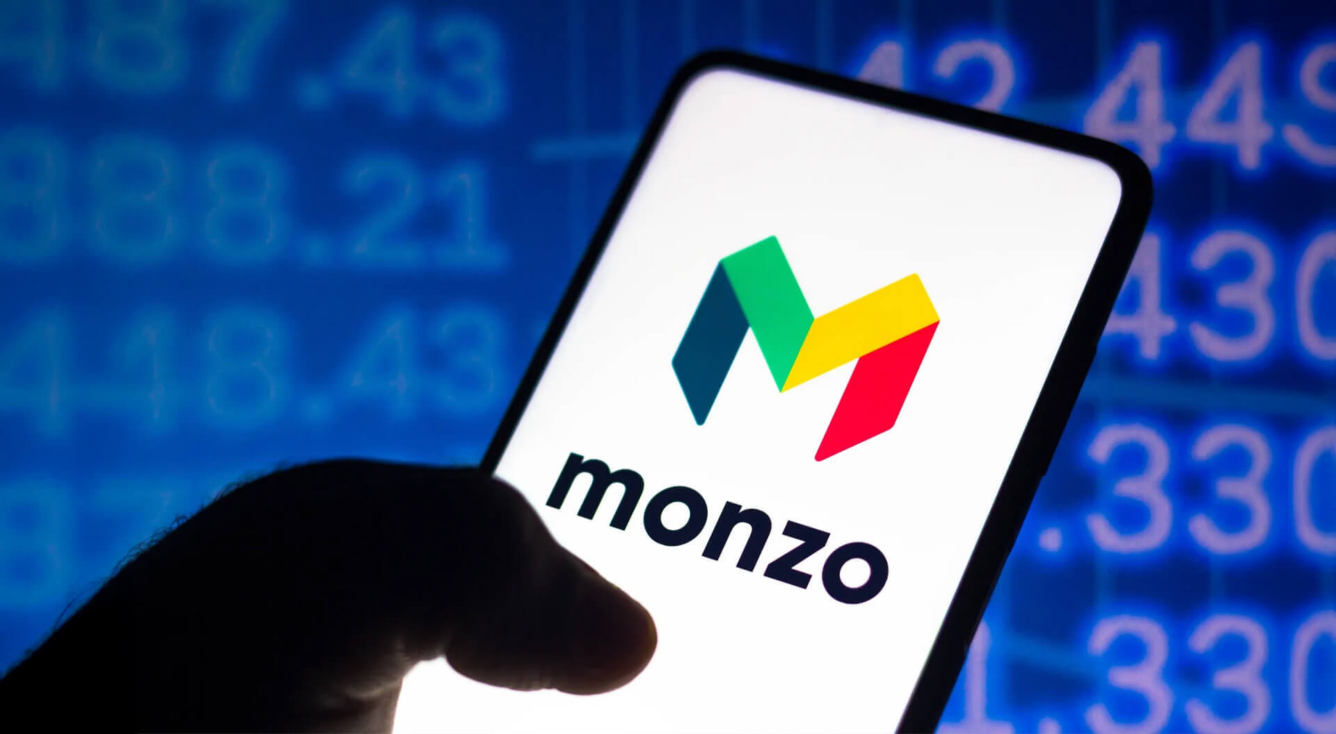 The image features the logo of Monzo, a prominent British digital bank. Monzo operates exclusively through a mobile app and has over 12 million customers.
