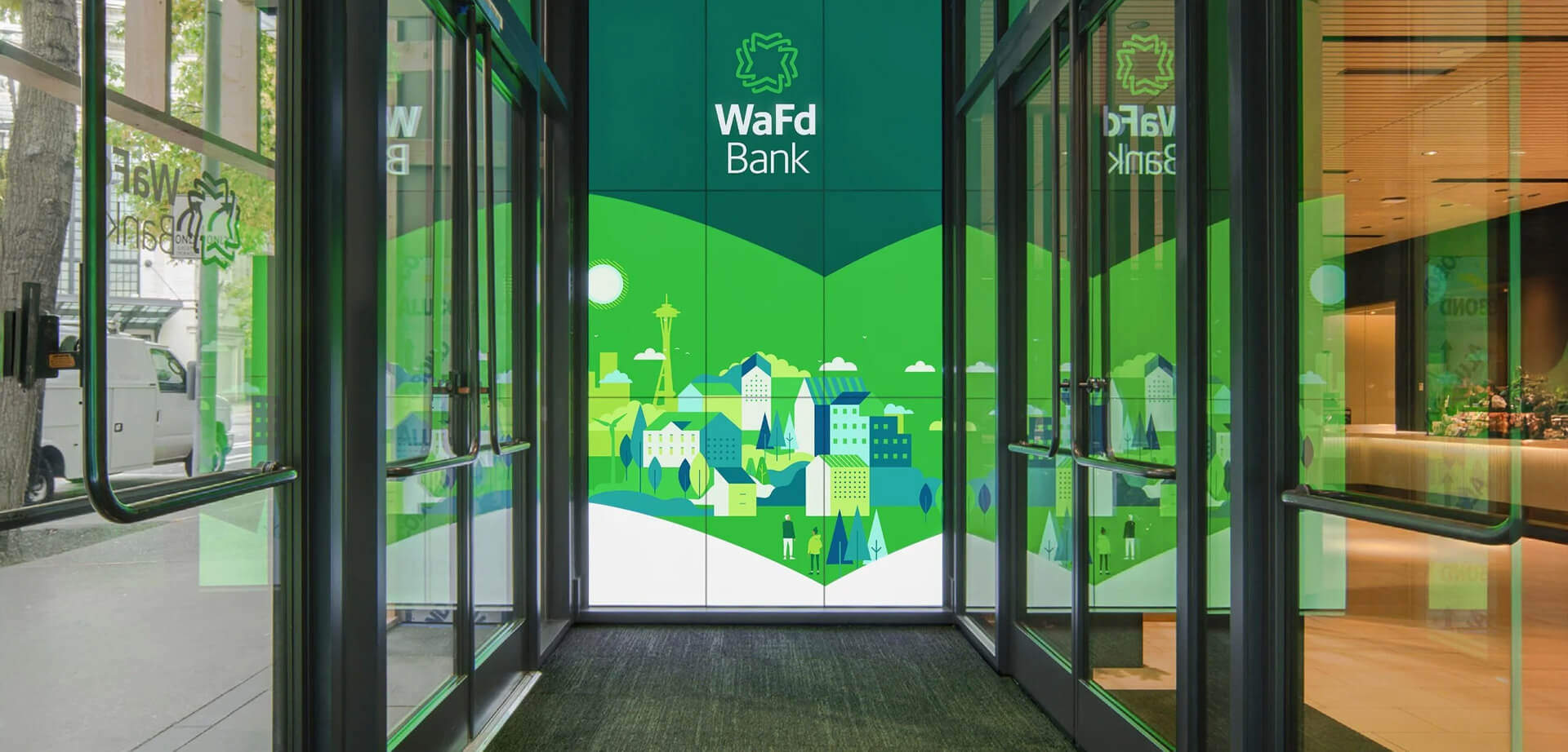 The illuminated digital display is a signature feature of the WaFd Bank headquarters in Seattle, showcasing a vibrant, 14-foot-tall animated mural of the city skyline.