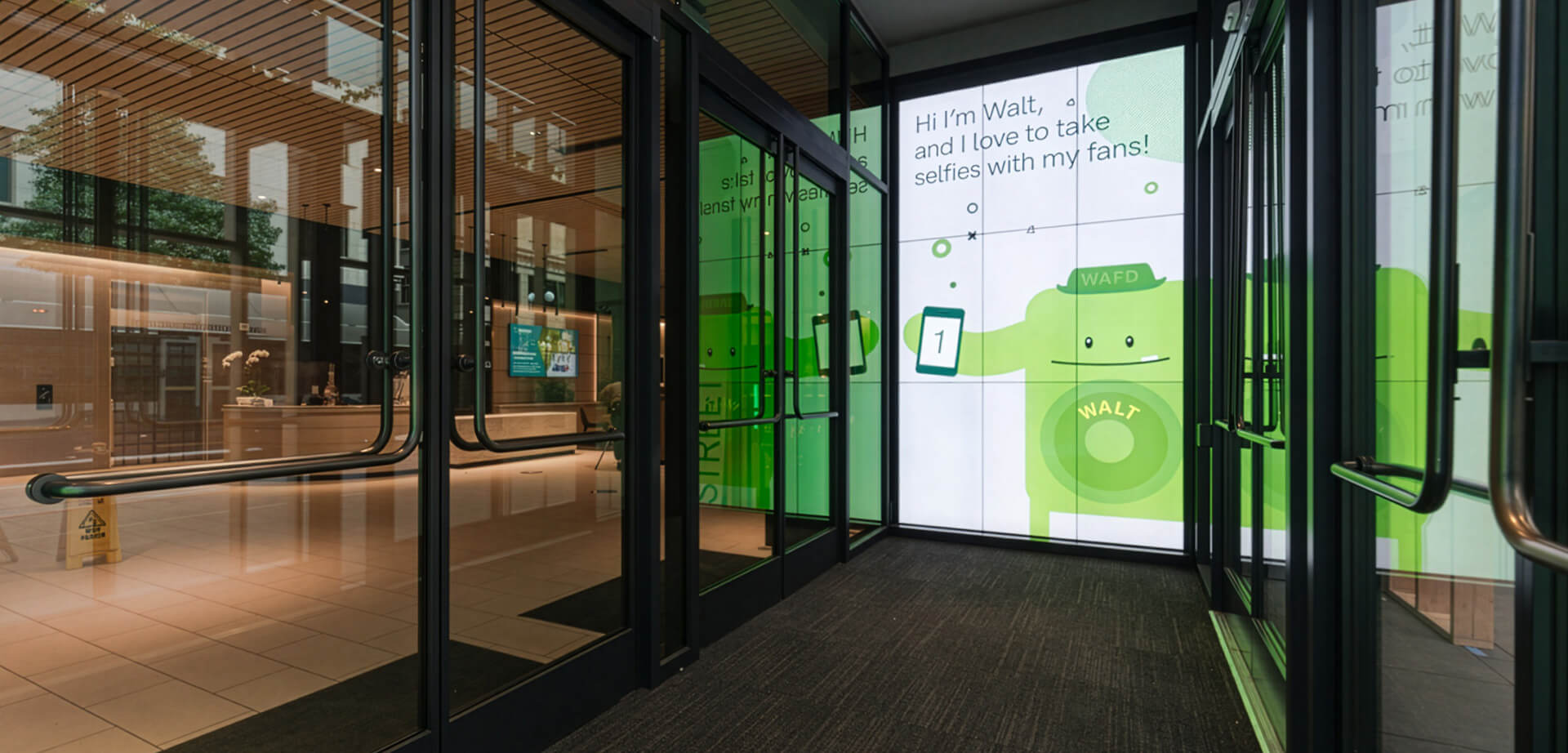 The large, interactive green graphic features "Walt," WaFd Bank's mascot, greeting visitors and encouraging them to take selfies with the screen.