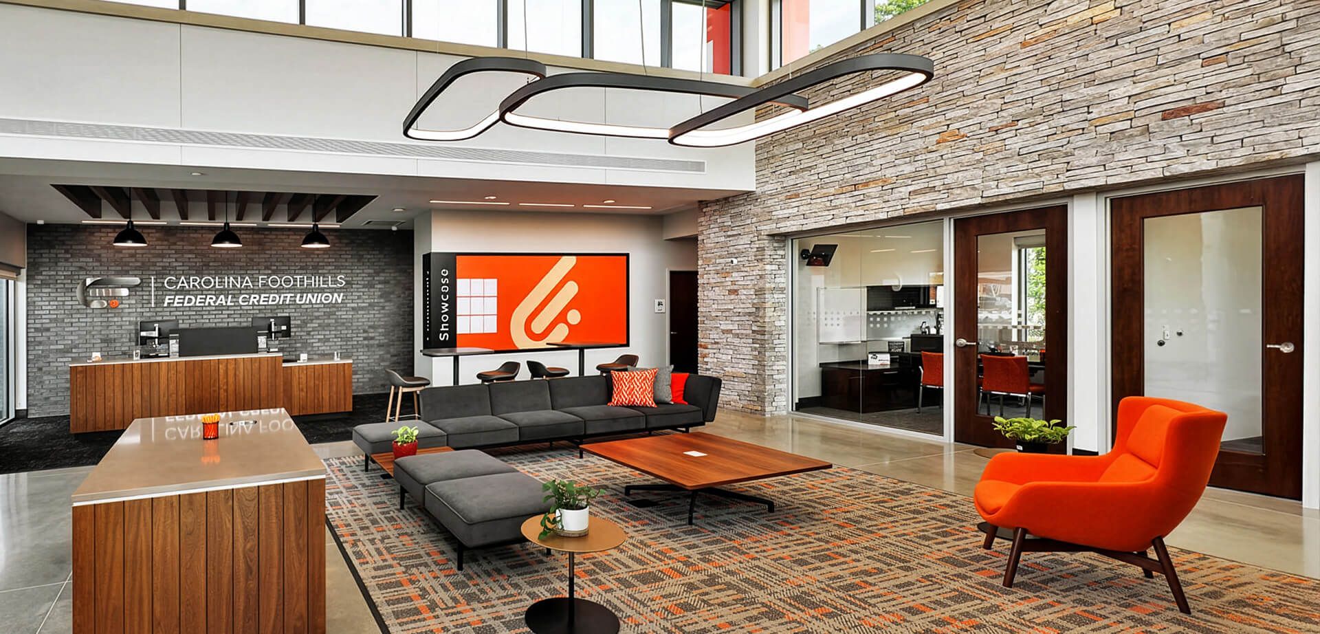 Carolina Foothills Credit Union. The branch was designed to create an inviting atmosphere for members, complete with flexible seating and a large visual display screen.