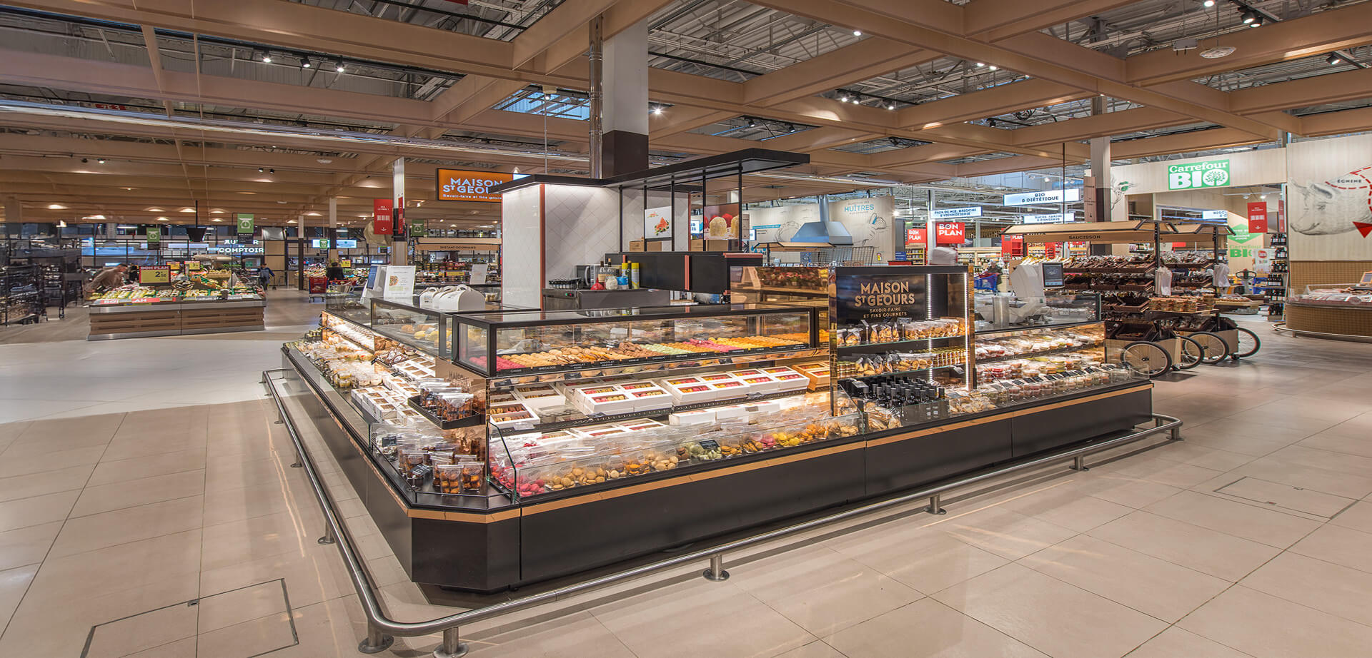 This bright, modern display is inside the Carrefour hypermarket in Villiers en Bière, France. The image captures a stylish, low-profile food counter that brings a premium, market-style feel to the large shopping space.
