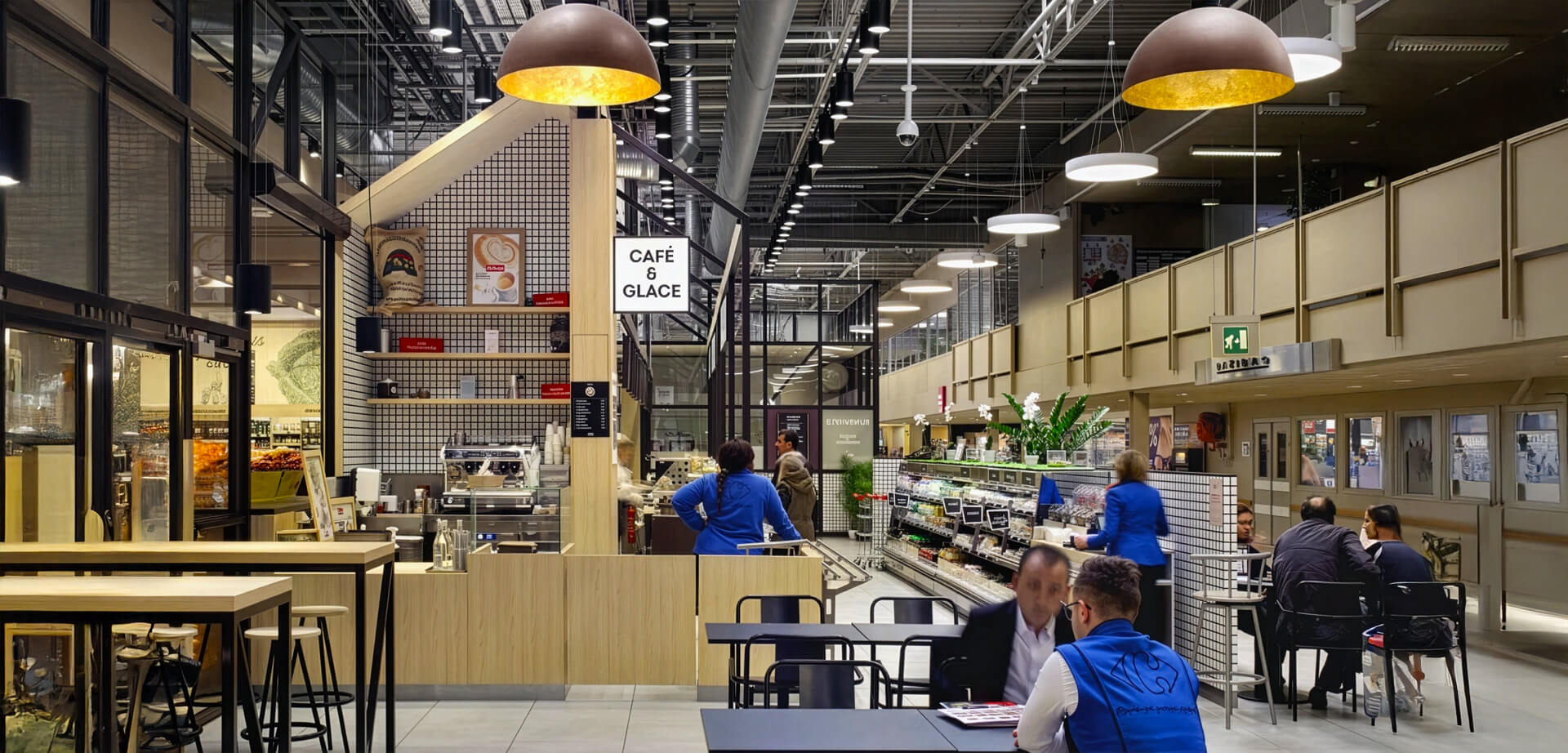 Carrefour hypermarket in Villiers-en-Bière, France. This renovated space blends retail and hospitality, featuring a dedicated "Café & Glace" counter and ample seating designed to enhance the overall shopping experience.
