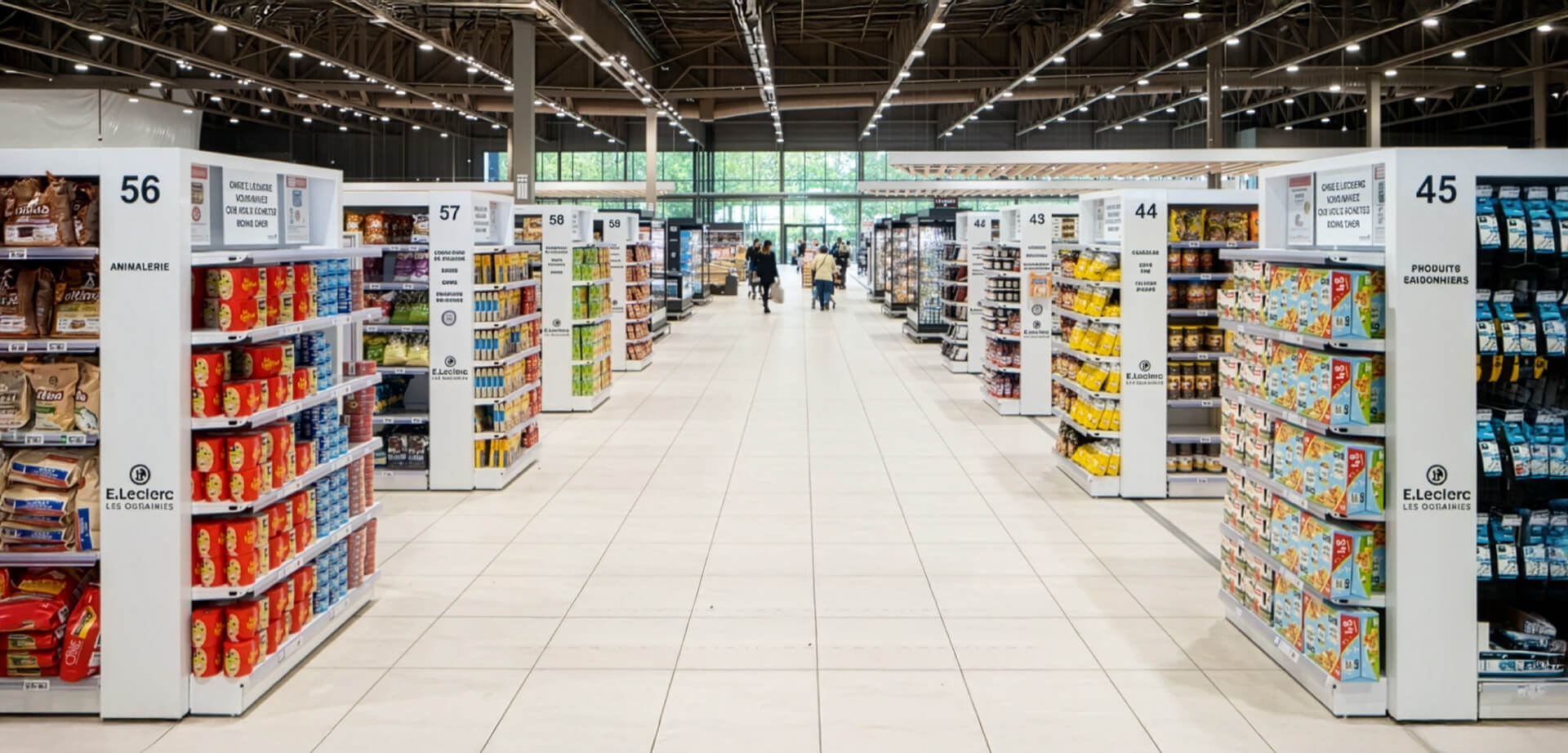 The interior of an E.Leclerc supermarket, specifically a store located in La Roche-sur-Yon, France. The picture highlights the wide, central aisles and modern, high shelving.