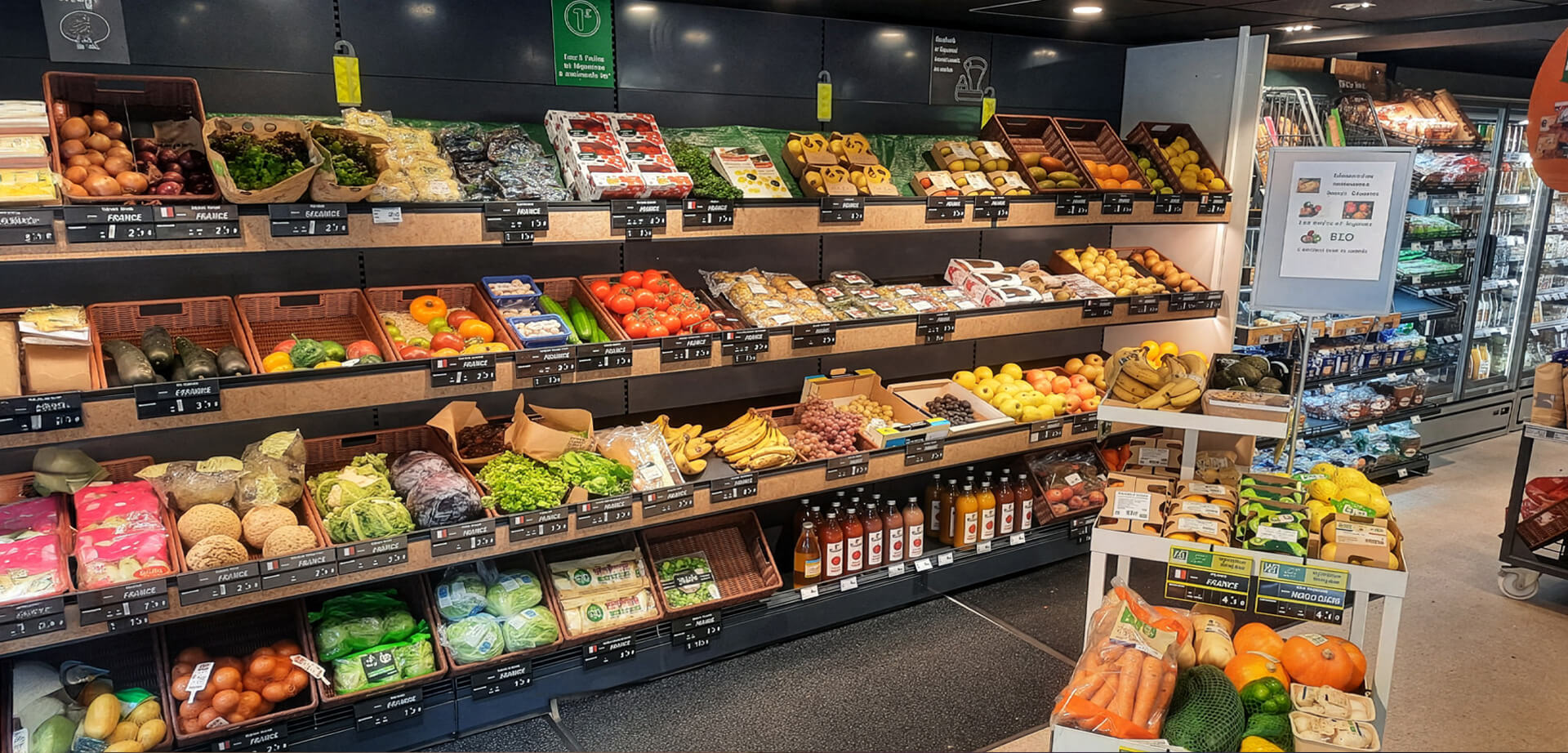 This image shows the fresh produce department inside the Carrefour Express convenience store in Alsace.