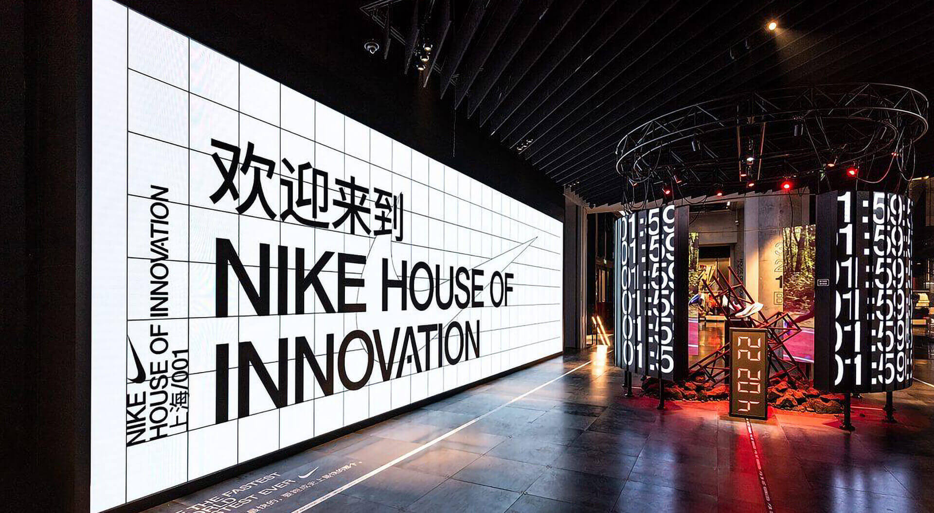 Nike House of Innovation flagship retail store (specifically the Shanghai location, labeled "上海/001"), featuring a large gridded LED welcome screen and immersive digital displays..